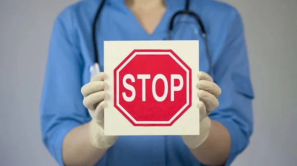 Γιατρός κρατώντας πινακίδα stop, προειδοποιώντας για ανθυγιεινό τρόπο ζωής, βλαβερές συνήθειες — Φωτογραφία Αρχείου