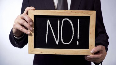 Hayır işaret tutan iş kişi yazı tahtası üzerinde ünlem işareti ile yazılı