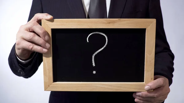 Ponto de interrogação escrito em quadro-negro, pessoa de negócios segurando um sinal nas mãos — Fotografia de Stock