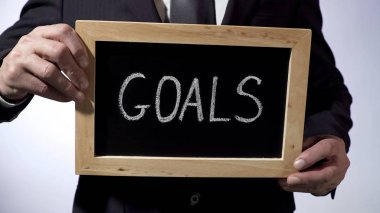 Yazı tahtası üzerinde işaret, iş kavramı holding Klasik takım elbiseli adam yazılı gol