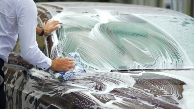 Pahalı carwash, köpük, iş temizlik ile meşgul erkek çamaşır elit araba