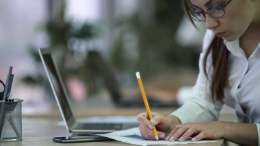 Profesyonel finansal analist notlar kağıtlara, raporda çalışan kadın yapma.