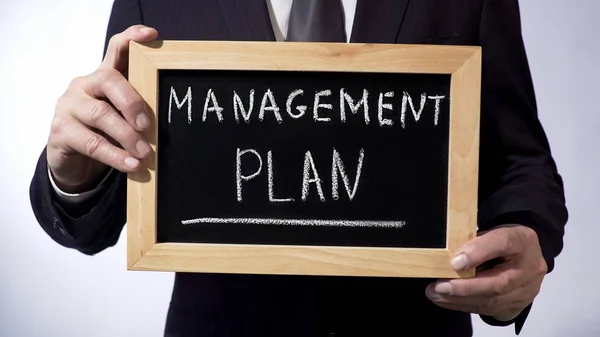 Plan de gestión escrito en pizarra, persona de negocios con signo, estrategia —  Fotos de Stock