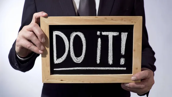 Do it with exclamation mark written on blackboard, male holding sign, motivation — Stock Photo, Image
