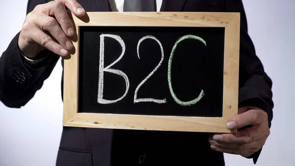 B2C, business-to-consumer written on blackboard, businessman holding sign — Stock Photo, Image