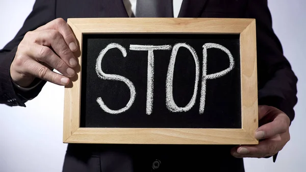 Stoppen met schriftelijke op blackboard, zakelijke houder teken, motivatie, eerlijkheid — Stockfoto