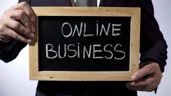Negócio online escrito em quadro-negro, empresário segurando sinal, freelance — Fotografia de Stock