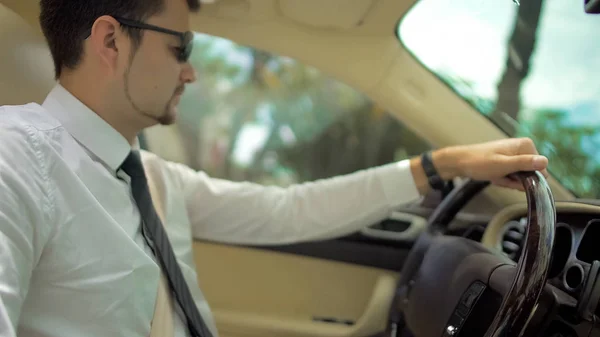 Hombre guapo conduciendo un coche caro al trabajo, servicio de transporte de clase empresarial — Foto de Stock