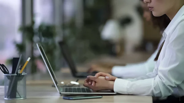 Serious female office employee sitting with hands folded, tired of boring job — Stock Photo, Image