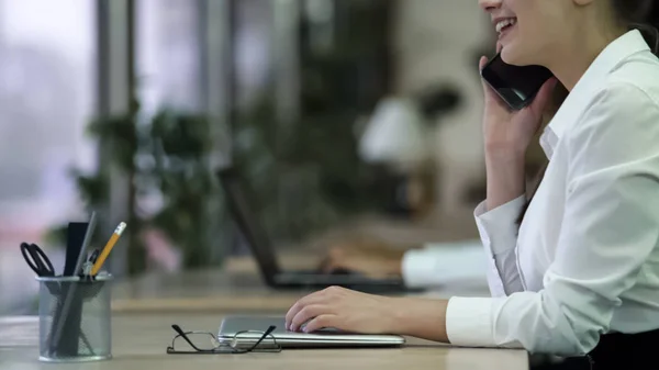 Gelukkig jongedame telefoon gesprek op kantoor, praten met een glimlach op het gezicht — Stockfoto