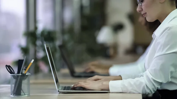 Succesvolle vrouwelijke typen van e-mail op laptop, lachende vrouw genieten van werk op kantoor — Stockfoto