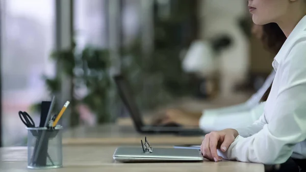 Vrouw gevouwen handen op tafel, zet de bril op laptop, vermoeide ogen, wazig zicht — Stockfoto