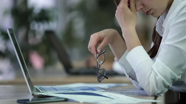 Mujer agotada gerente quitándose las gafas y frotándose los ojos, empleado sobrecargado de trabajo —  Fotos de Stock