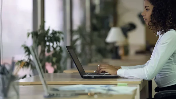 Mooie vrouw van gemengd ras typen op laptop, journalist schrijven artikel geïnspireerd — Stockfoto