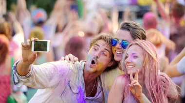 Gülümseyen ve Smartphone, renk Festivali, selfie için poz arkadaşlar eğlenmeye