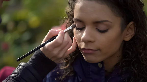 Maquillaje artista aplicando sombra de ojos en los ojos de modelo o actriz, blog de belleza — Foto de Stock