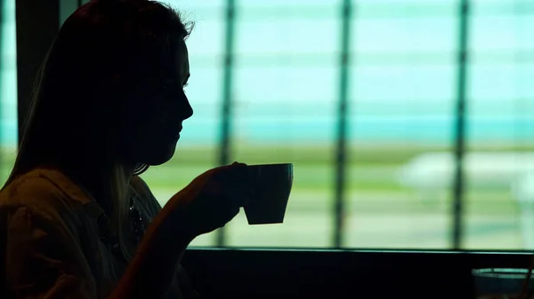 Jeune femme assise au restaurant de l'aéroport et dégustant du café chaud, tourisme — Photo