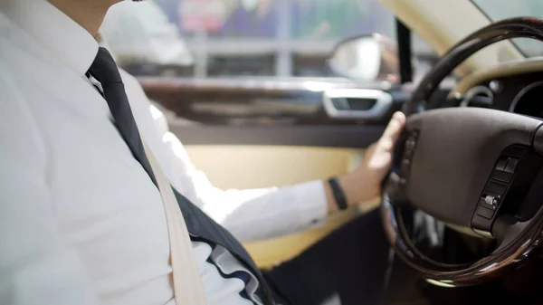 Persönlicher Chauffer im Business-Anzug, der Luxusautos fährt, teure Dienstleistungen — Stockfoto