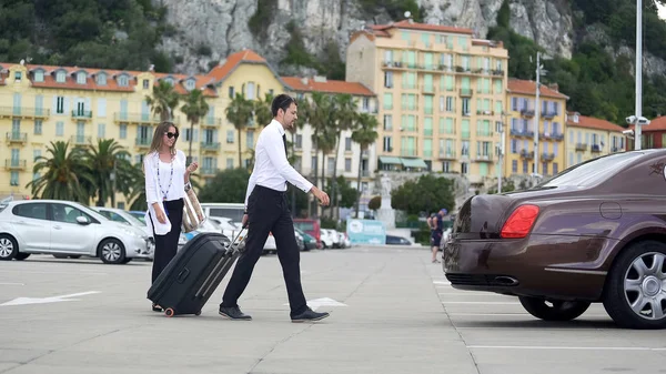 Beautiful businesswoman walking to taxi with chauffer, luxury car services — Stock Photo, Image