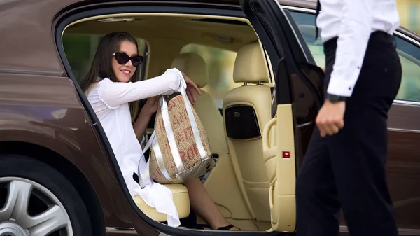 Частный шофер, открывающий двери для красивых женщин-пассажиров, автосервис — стоковое фото