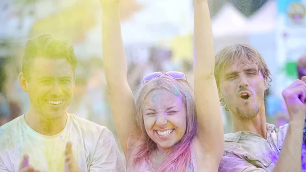 Felices amigos sonrientes bailando en polvo de color, festival de verano emociones alegres — Foto de Stock