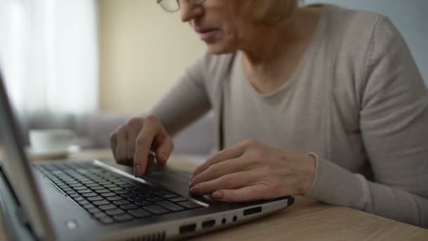 Mujer anciana escribiendo lentamente en el ordenador portátil en casa, cursos de informática, formación en línea — Vídeos de Stock