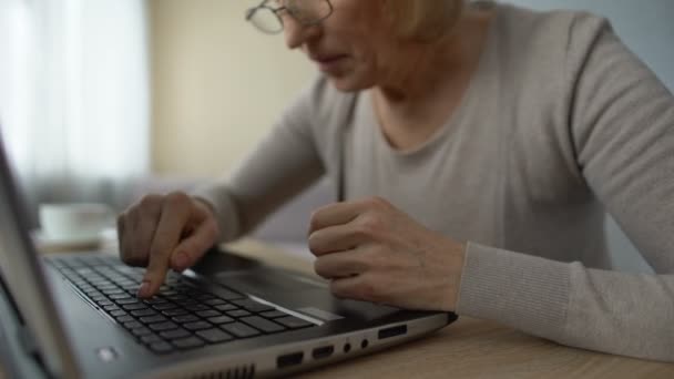 Пенсионерка, изучающая новую компьютерную программу, сердито нажимающая клавиши — стоковое видео