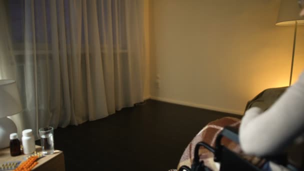 Pracownika medycznego przynosząc przygnębiony stara kobieta na wózku inwalidzkim do pokoju, samotność — Wideo stockowe