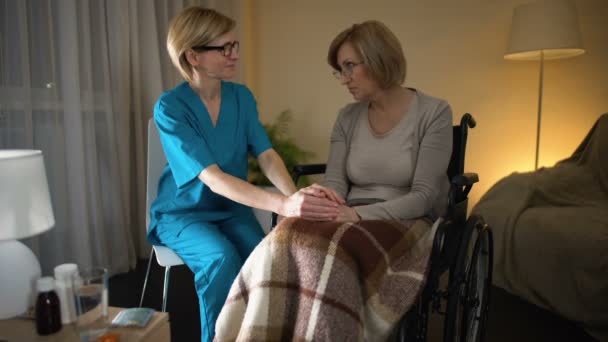 Krankenschwester tröstet alte kranke Dame im Rollstuhl während der Erholungsphase, Einsamkeit — Stockvideo