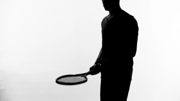 Силуэт теннисиста практикует реакцию, отскакивая мяч на белом фоне — стоковое видео