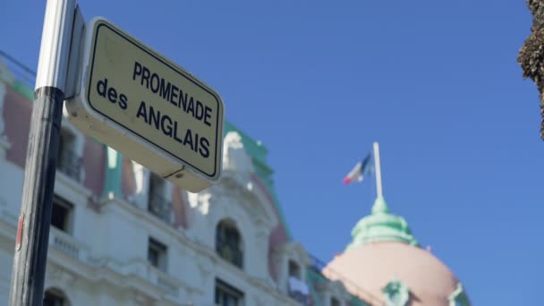 Υπογράψει δρόμο Promenade des Anglais, γαλλική σημαία να κυματίζει στην κορυφή του κτιρίου στη Νίκαια — Αρχείο Βίντεο