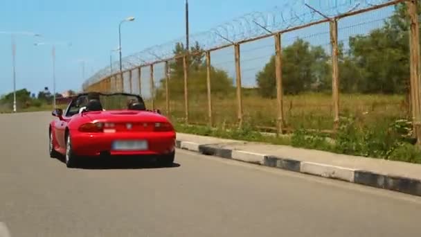 Jeune couple bénéficiant d'un tour à grande vitesse en rouge décapotable auto, vie insouciante — Video