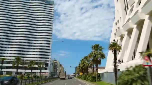 Vista desde el coche que conduce la calle de la ciudad grande, pasando hoteles y edificios de apartamentos — Vídeos de Stock