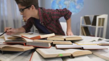 Çocuk heyecanla yığın kitap bilgi arayan ilgi ile