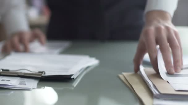Менеджер мужского офиса проверяет документы на столе и заполняет финансовый отчет — стоковое видео