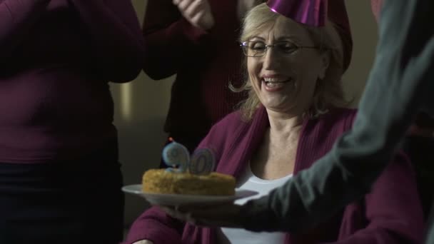 Члени сім'ї плескають і обіймають 90-річну бабусю на вечірці — стокове відео