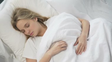 Kaprisli kız battaniye üzerinde kafa çekerek sabah daha fazla zaman uyumaya çalışıyor