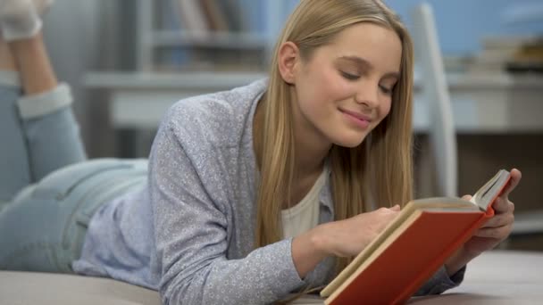 Симпатичная девушка наслаждается романтическими стихами, читает книгу, мечтает об идеальных чувствах — стоковое видео