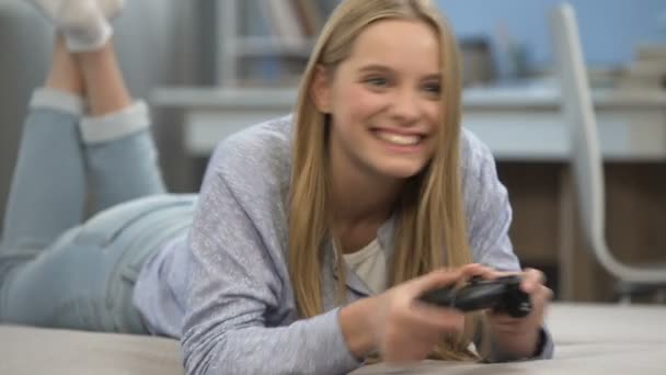 Adolescente chica gamer jugando shooter con joystick, muy emocional, feliz de ganar — Vídeo de stock