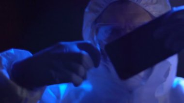Erkek Müfettiş kurban smartphone suç parmak ile plastik torbaya koyar.