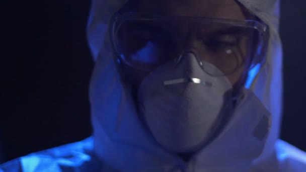 Криминалист в белой защитной маске держит пластиковый пакет с белым порошком — стоковое видео