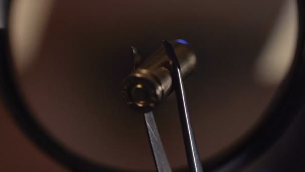 Expert en balistique examinant les preuves par balle avec loupe, gros plan 