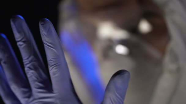 Genius doctor putting on gloves before biology experiment in secret clinic — Stock Video