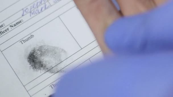 Офицер полиции снимает отпечатки пальцев главного подозреваемого, биометрический опознавательный знак — стоковое видео