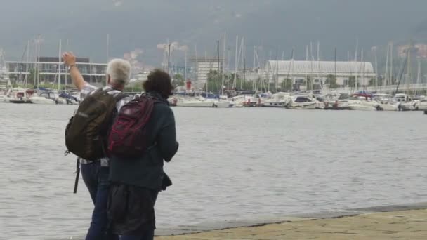 У віці пара з рюкзаками, sightseeing гавані в Італії, активного відпочинку — стокове відео