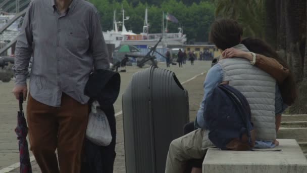 Amar pareja joven sentado en el banco en el puerto deportivo de Spezia, cita romántica al aire libre — Vídeo de stock