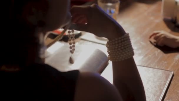 Привлекательная женщина с жемчужным ожерельем сидит в ресторане и выбирает еду — стоковое видео