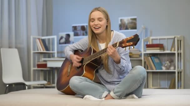 Женщина-гитаристка исполняет песню дома, творческое хобби, готовится к прослушиванию — стоковое видео