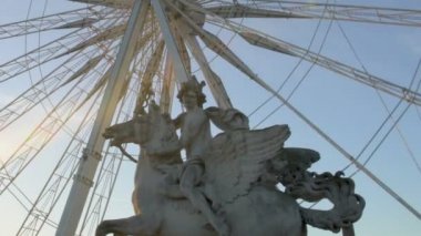 Pegasus binicilik heykeli önünde büyük tekerlek Anıtı günbatımı, kuşlar