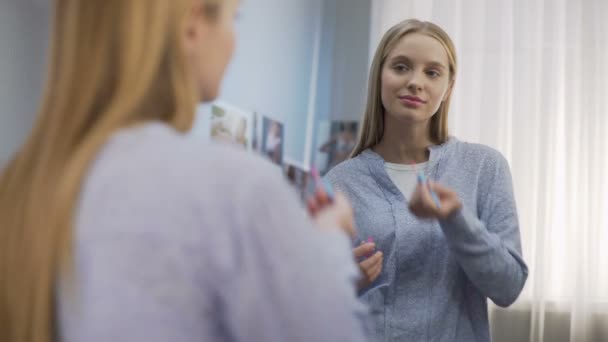 Uśmiechający się nastolatek kobiece zakładanie błyszczyk i patrząc w lustro, uroda — Wideo stockowe